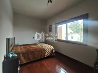 Quarto com cama e janela de madeira no interior da propriedade.