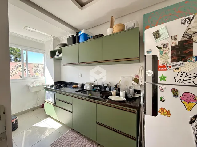 Foto de uma cozinha com armários verdes e bancada escura.
