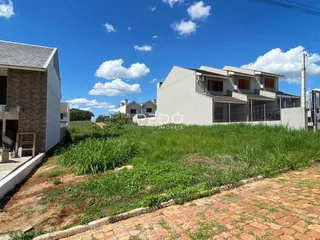 A fachada de uma casa moderna em Lajeado, Brasil, com jardim gramado em primeiro plano.