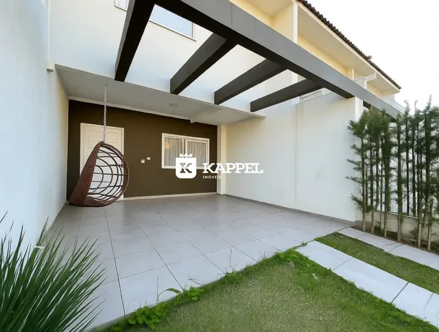 Fachada de uma residência com área externa coberta e piso de concreto.