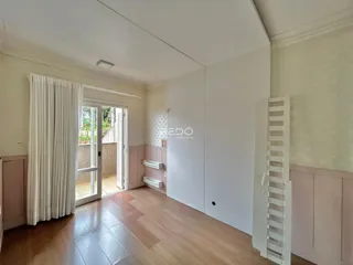 Ambiente interno com piso de madeira e portas de vidro.