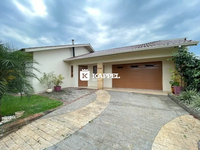 Vista externa da fachada de uma casa residencial em Lajeado, Brasil, mostrando a garagem e o jardim.