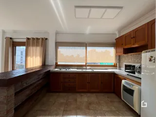Foto de uma cozinha com armários de madeira e piso de cerâmica.