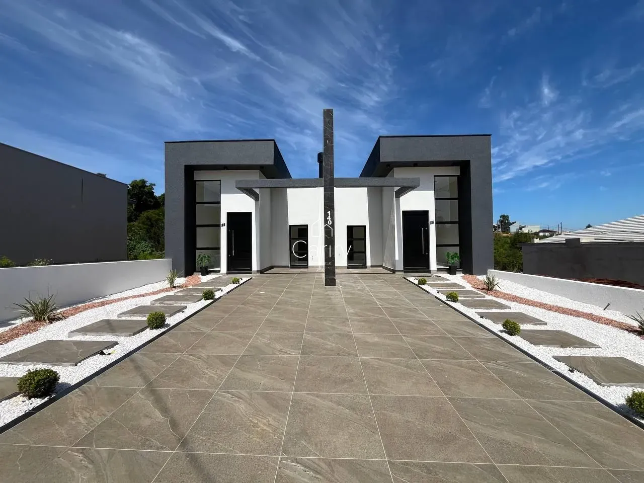Fachada moderna de uma residência em Lajeado, Brasil, com paisagismo frontal.