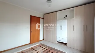 Quarto com armários embutidos e piso de madeira clara.