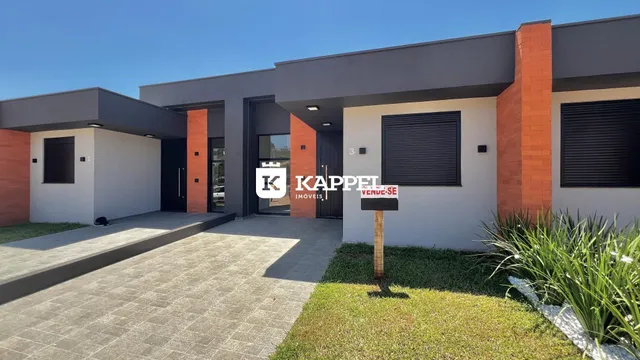 Fachada de uma residência moderna com paredes brancas e detalhes em tijolo aparente, com paisagismo frontal.