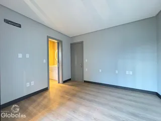 Foto de um corredor interno com piso de madeira clara.