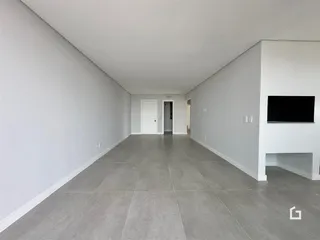 Corredor longo com paredes brancas e piso cinza claro.