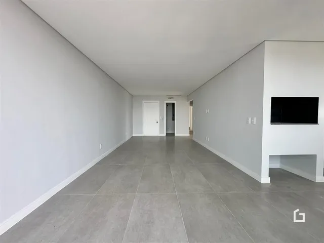 Corredor longo com paredes brancas e piso cinza claro.