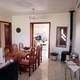 Foto de um ambiente de jantar com mesa e cadeiras de madeira.