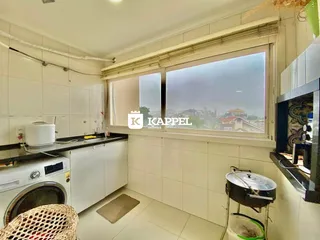 Cozinha com janela que oferece uma vista da paisagem urbana.