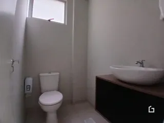 Foto de um banheiro com vaso sanitário e pia brancos.