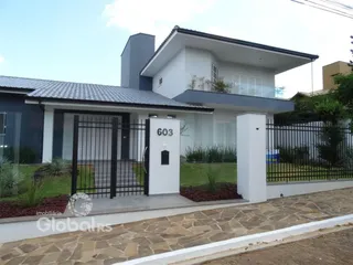 Fachada de uma casa moderna em Lajeado, Brasil, com muro e portão preto.