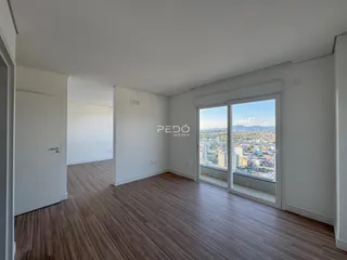 Sala de estar com piso de madeira e vista da cidade.