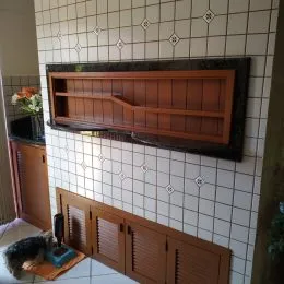 Parede com revestimento de azulejos brancos e painéis de madeira marrom.