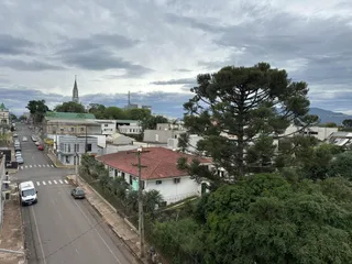 Vista externa de uma rua residencial com casas e uma igreja ao fundo em Lajeado.