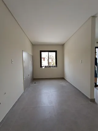Hall de entrada com paredes brancas e piso cinza claro.