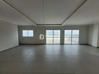 Ambiente interno amplo com piso de cerâmica e grandes janelas voltadas para o horizonte.