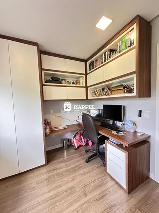 Foto de um escritório com estantes e mesa de trabalho em um ambiente interno.