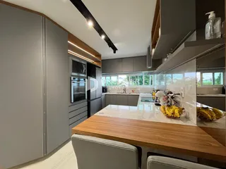 Cozinha moderna com armários cinzas e ilha de madeira.