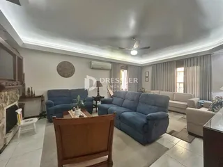 Sala de estar com sofás azuis e lareira em um imóvel no Brasil.