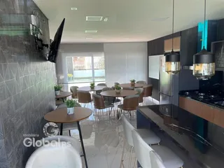 Ambiente de sala de jantar e cozinha moderna com mesas redondas.