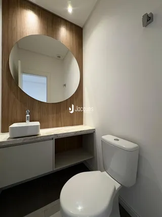 Banheiro moderno com bancada de mármore e revestimento de madeira.