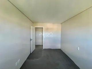 Hall de propriedade com paredes brancas e piso cinza escuro.
