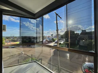 Vista da rua e casas em Lajeado, Brasil através de grandes janelas de vidro.