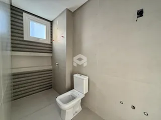 Foto de um banheiro com revestimento de azulejos e piso claro.