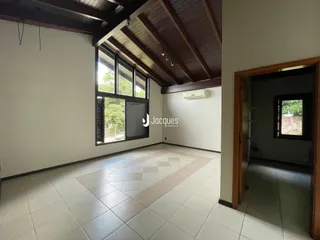 Interior de uma sala com piso de cerâmica e forro de madeira.