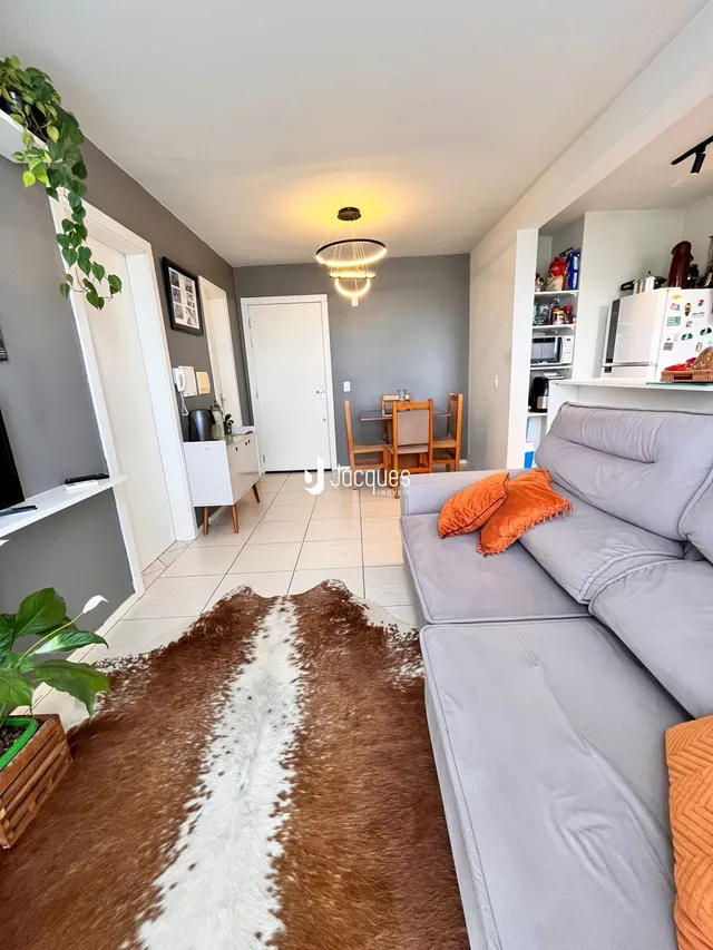 Sala de estar com sofá e tapete na residência.