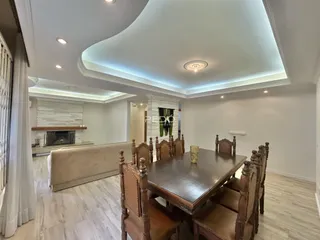 Sala de estar com lareira e mesa de jantar de madeira em um apartamento.