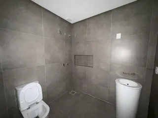 Banheiro com piso de cerâmica e louças brancas.