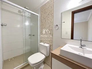 Foto de um banheiro moderno com box de vidro e azulejos brancos.