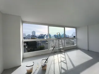 Vista da sala com grande janela de vidro em um apartamento.