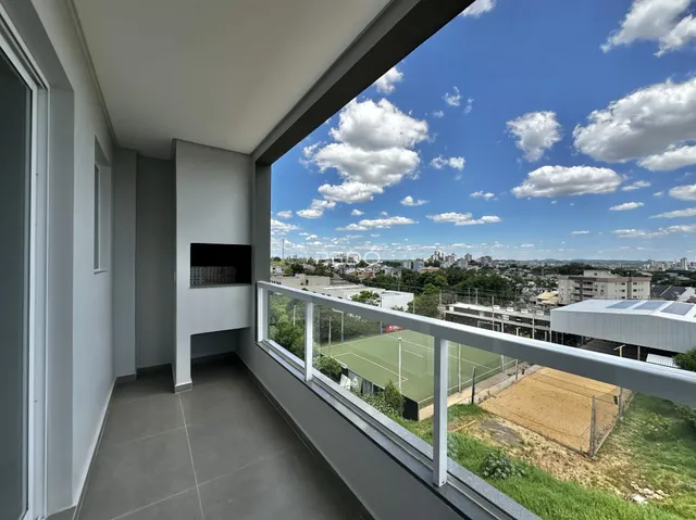 Vista da varanda com paisagem urbana e campos.