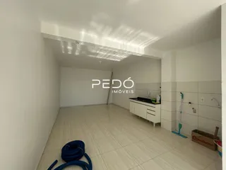 Interior de uma sala com piso de cerâmica clara e paredes brancas.