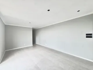 Hall de corredor com piso de cerâmica e paredes brancas.