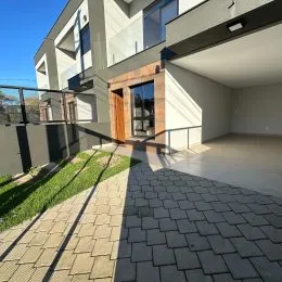 Vista externa do imóvel mostrando um pátio pavimentado com grama.