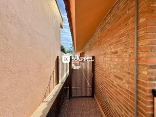 Vista externa de um corredor estreito entre duas edificações em Lajeado.