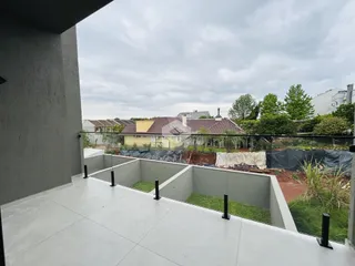 Vista da varanda com piso de concreto e grade de proteção.