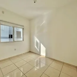 Vista interna de um cômodo com piso de cerâmica e paredes brancas.