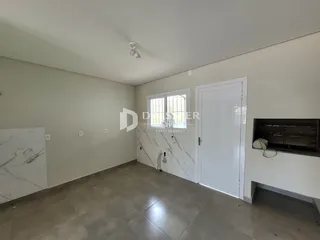 Interior de um ambiente com piso de cerâmica e parede de mármore claro.