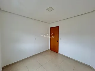 Ambiente interno de uma sala com paredes brancas e piso de cerâmica.