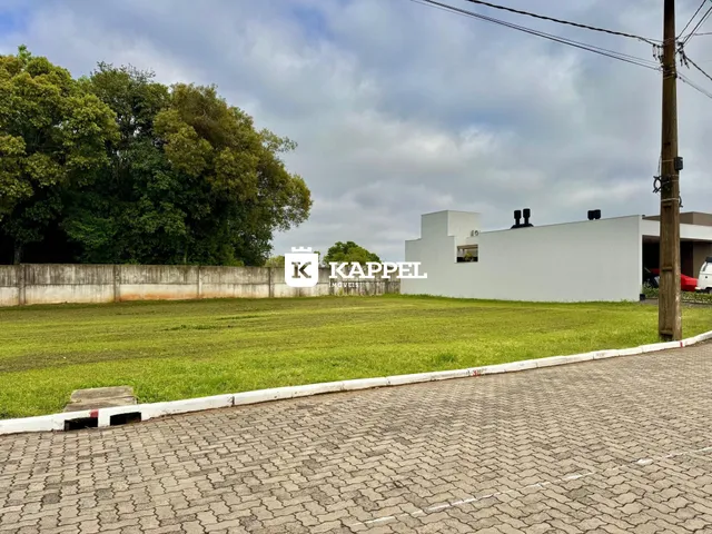 Vista externa de uma propriedade com gramado e construção branca em Lajeado.