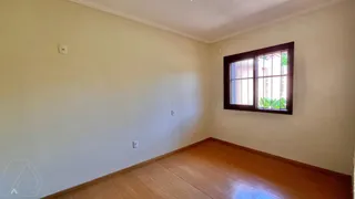 Vista interna de um cômodo com piso de madeira e janela.