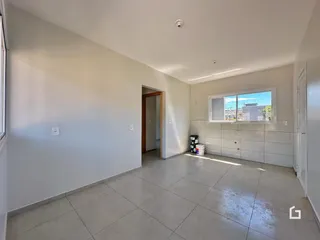 Ambiente interno com piso de cerâmica e paredes brancas em um imóvel.