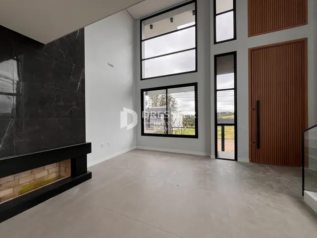 Ambiente interno de uma sala com piso claro e parede de destaque em mármore escuro.