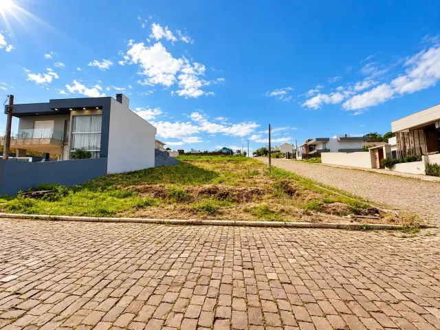Fachada de uma residência moderna em Lajeado, Brasil, com área externa pavimentada e gramado.
